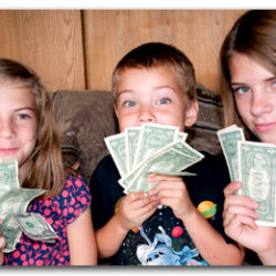 Three children holding money