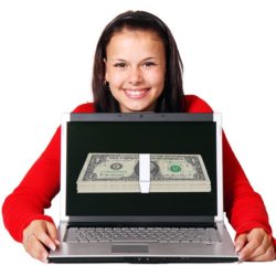 Woman holding a laptop with money on the screen.